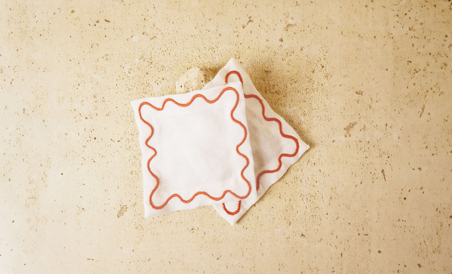 White cocktail napkins with red wavy embroidered border