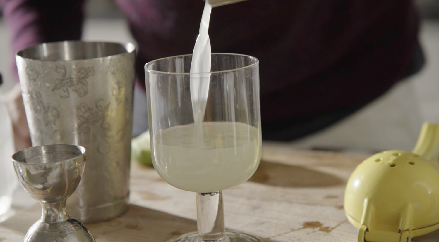 Pouring southside cocktail into glass