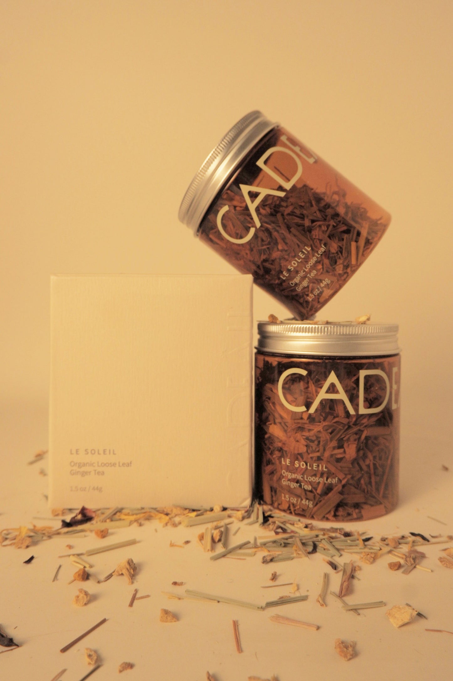 Stacked tea jars next to embossed tea box packaging 