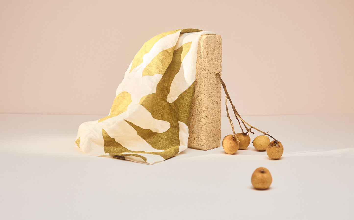 Teatowel draped over stone. Green and cream 